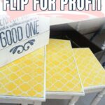 White side table with three yellow-patterned panels and a white wooden sign that reads Good One.