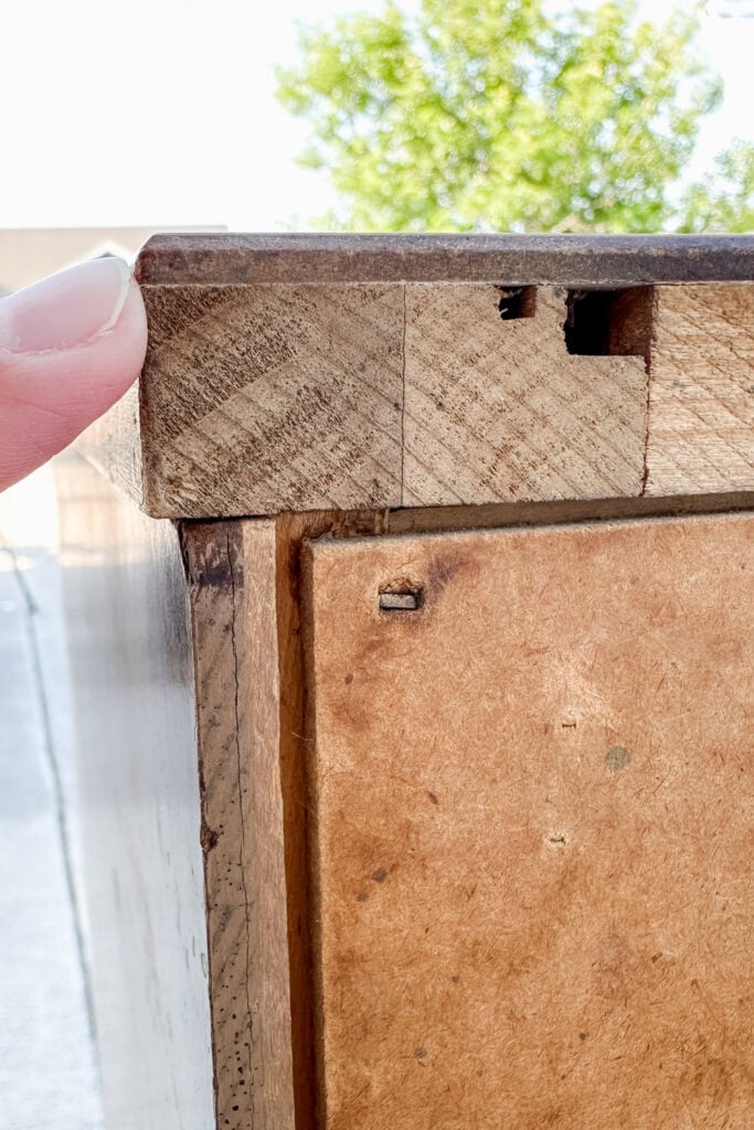 Hand pointing to laminate top of wood furniture