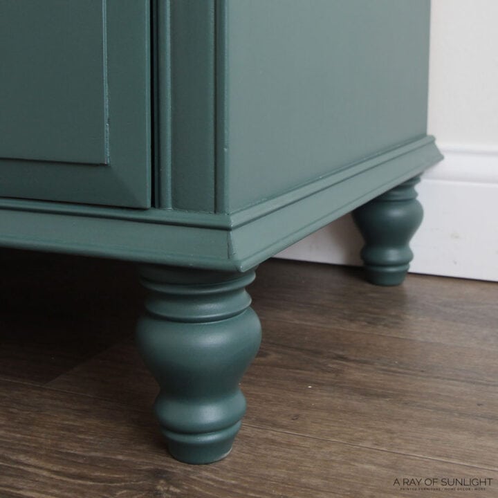 Close-up of dark green painted wooden furniture legs