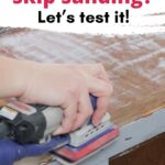 Hand using an electric sander on a wooden surface