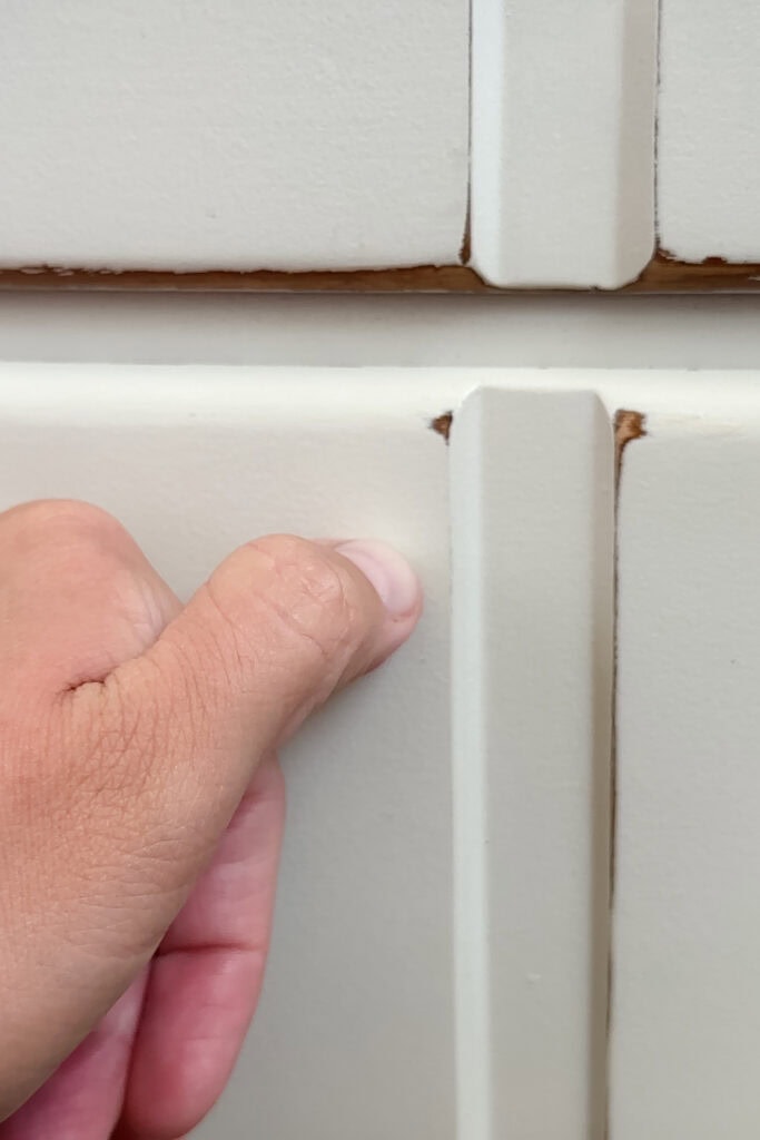 Thumb scratching white paint on furniture