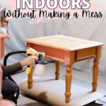 Person spray painting a wooden table indoors with text: How to paint furniture indoors without making a mess.