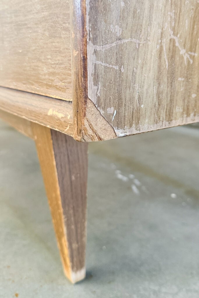 Closeup of the damage on an edge of a wooden dresser