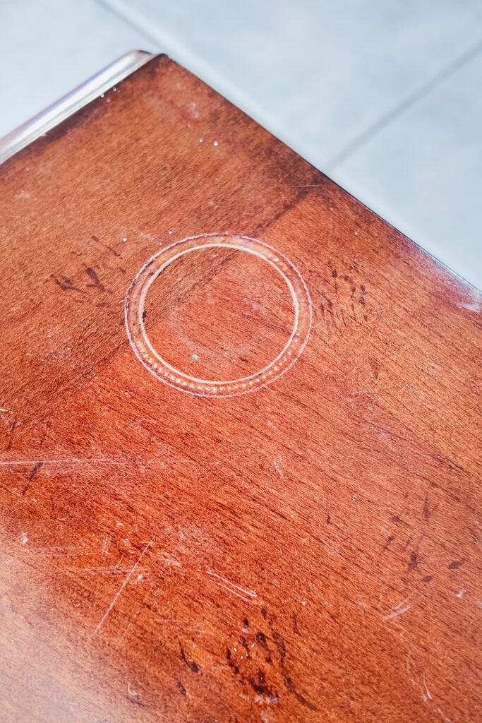 A wooden surface with a circle candle stain