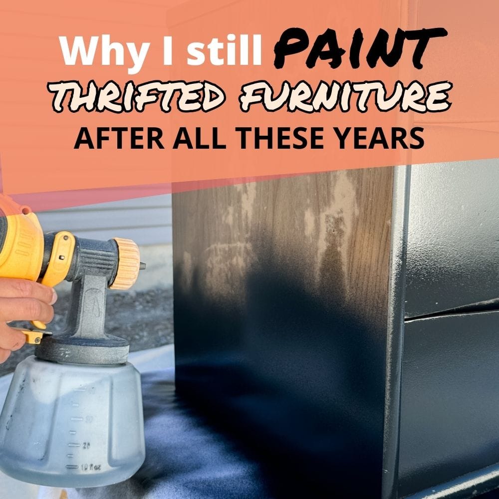 A hand uses a paint sprayer to paint a dresser dark