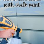 A person uses a paint sprayer on drawers