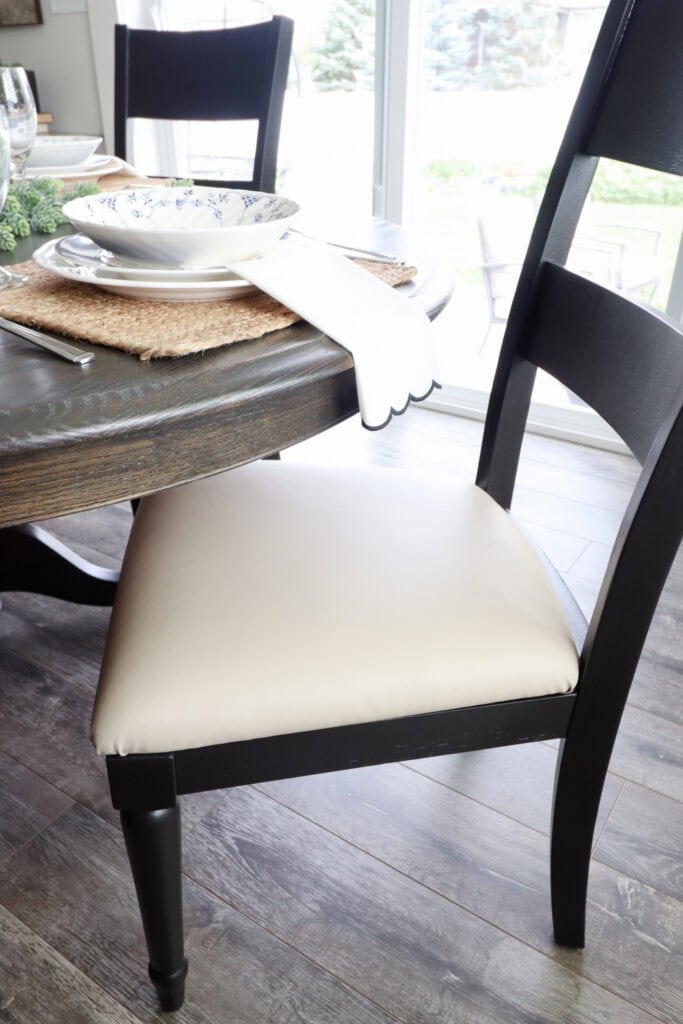 Black dining chair with a cream leather cushion