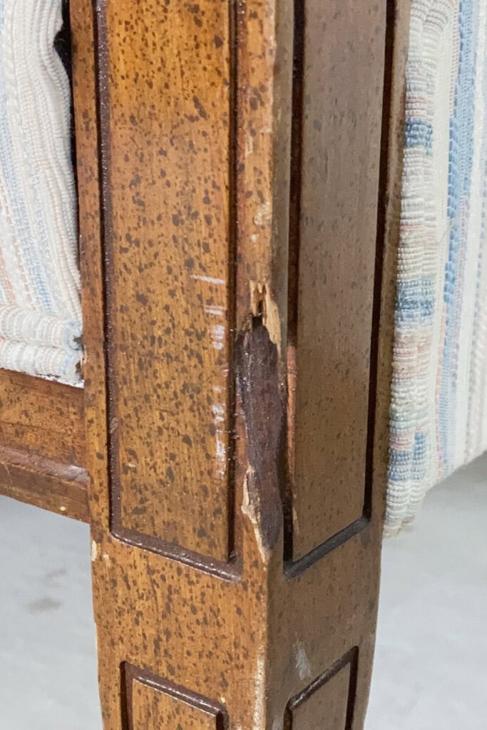 Closeup of a wooden chair leg with visible damage