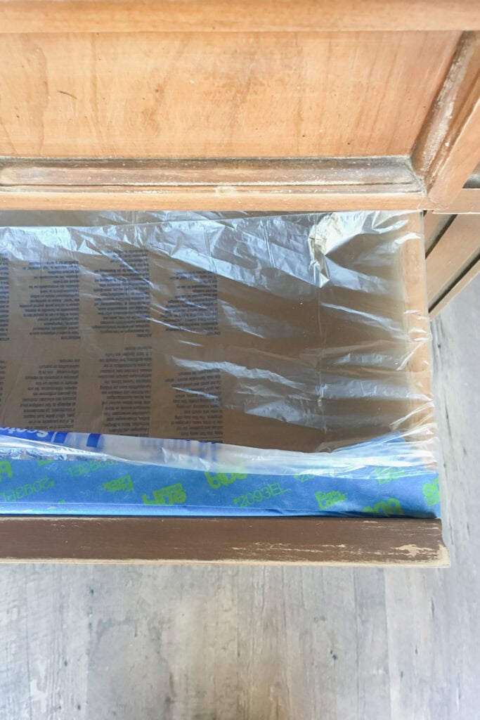 Open wooden drawer covered with pretaped plastic