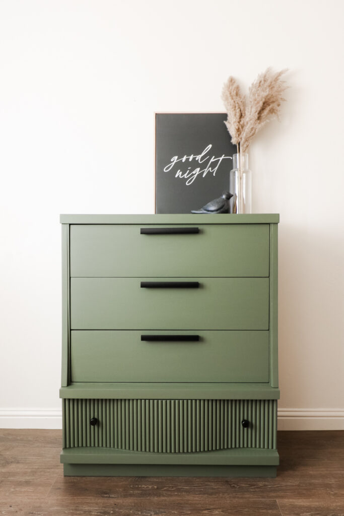 Green dresser with three drawers and one drawer with fluted design