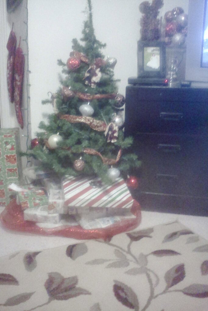 Black dresser next to small decorated Christmas tree