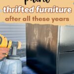 A hand spray paints a dresser black
