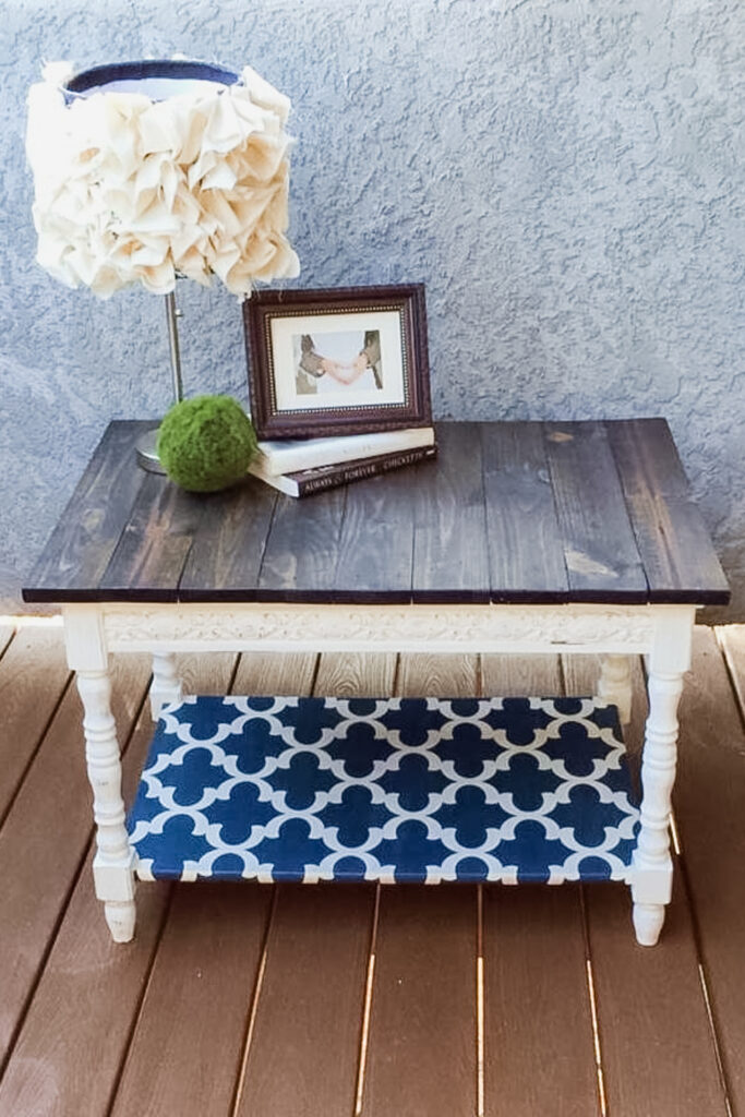 White wooden side table with a shelf with blue pattern.