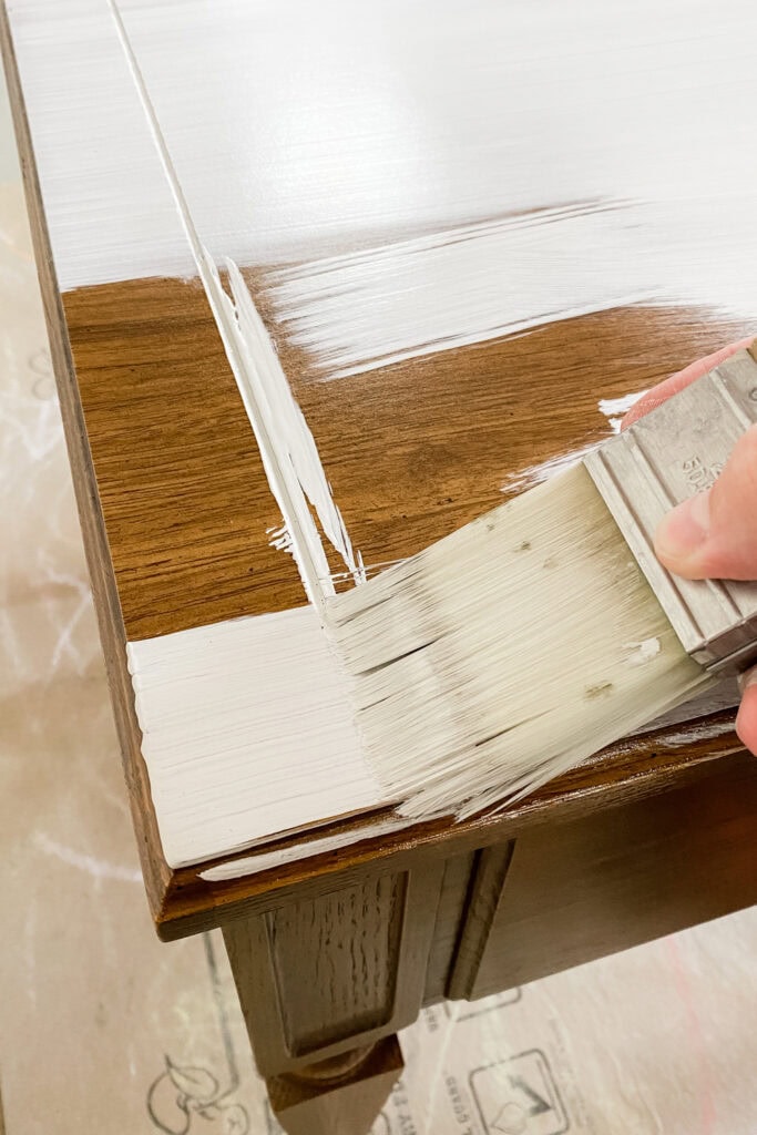 Applying white paint with a paintbrush.
