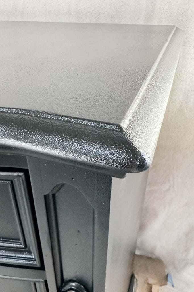 Closeup of a black painted dresser corner with texture