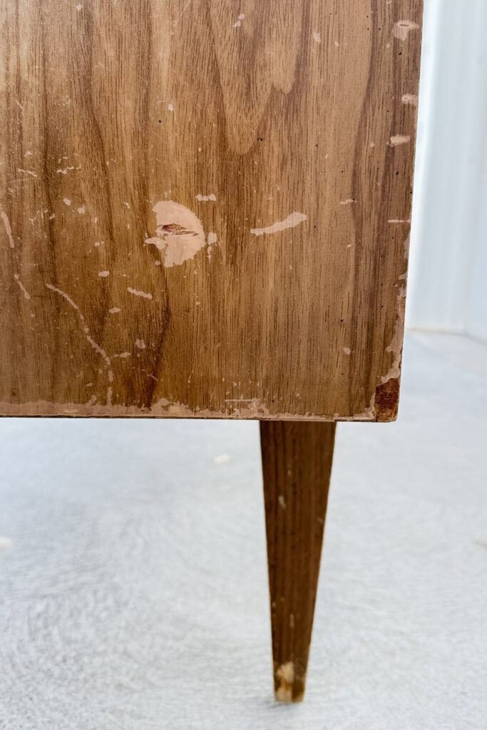 Closeup of wooden furniture with scratches, scuffs, and chips