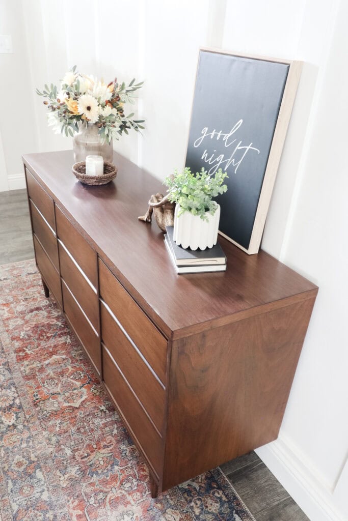 Top view of stained dresser with decor items on it