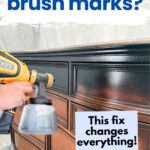 A person sprays paint onto a wooden dresser