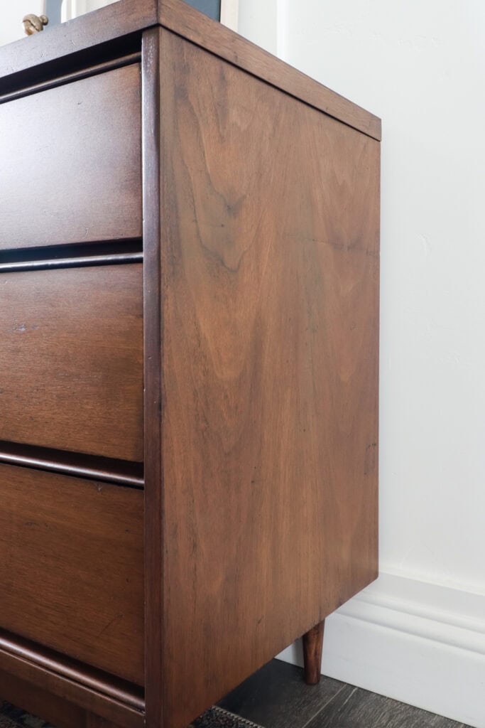 Closeup of side of wood dresser with fixed scratches