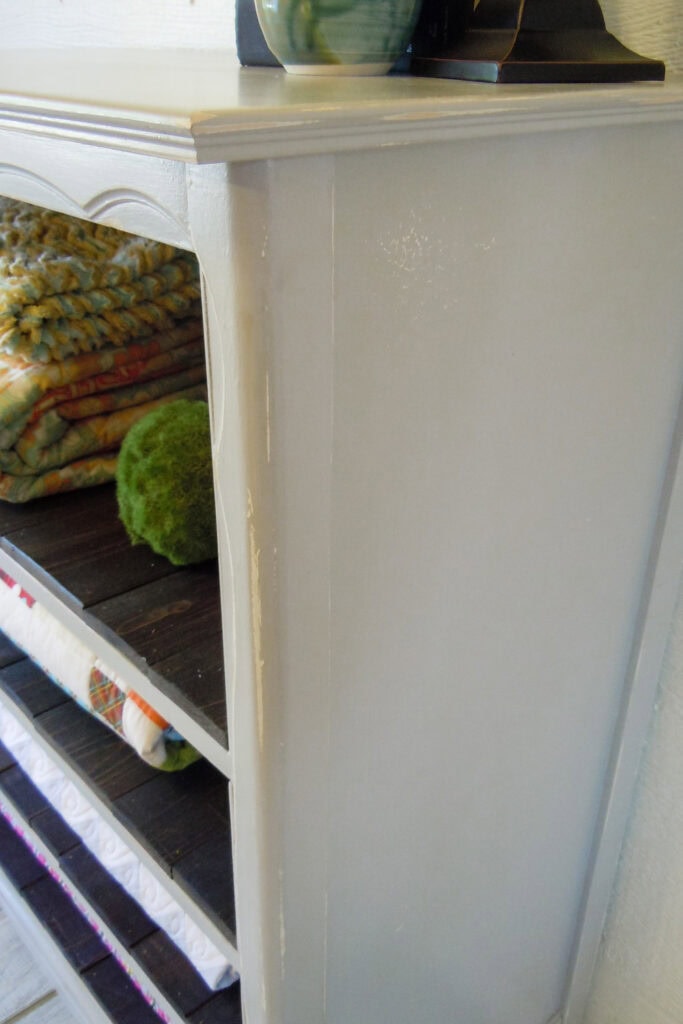 Closeup of the side of grey shelf dresser