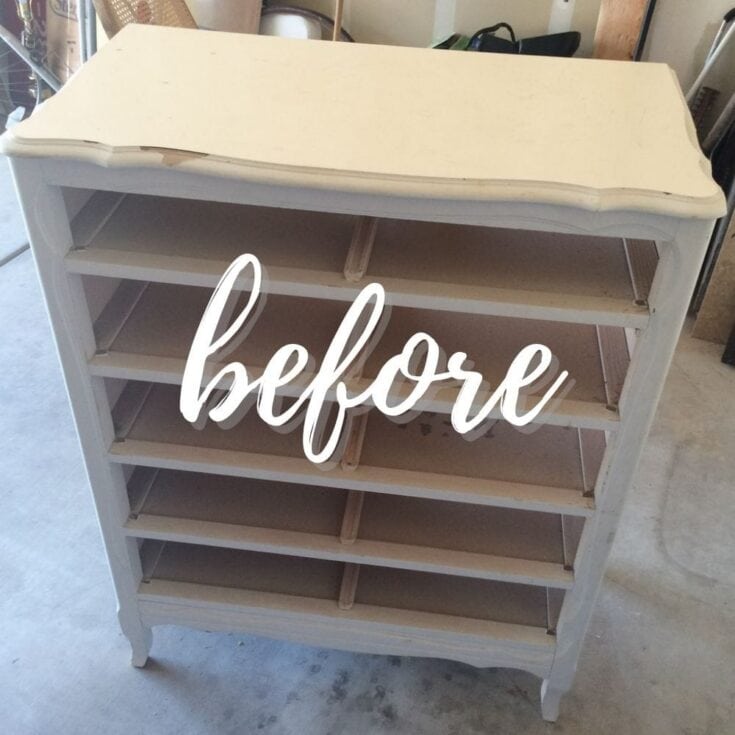White dresser without drawers in a garage, with before written across the front.