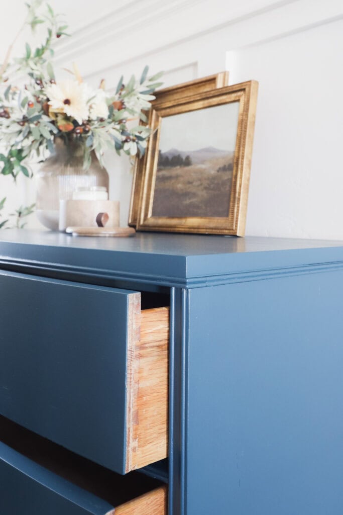 Closeup of blue dresser with partially open drawers