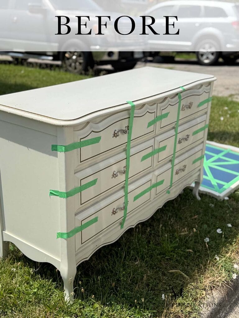 French white dresser with green tape sits on grass