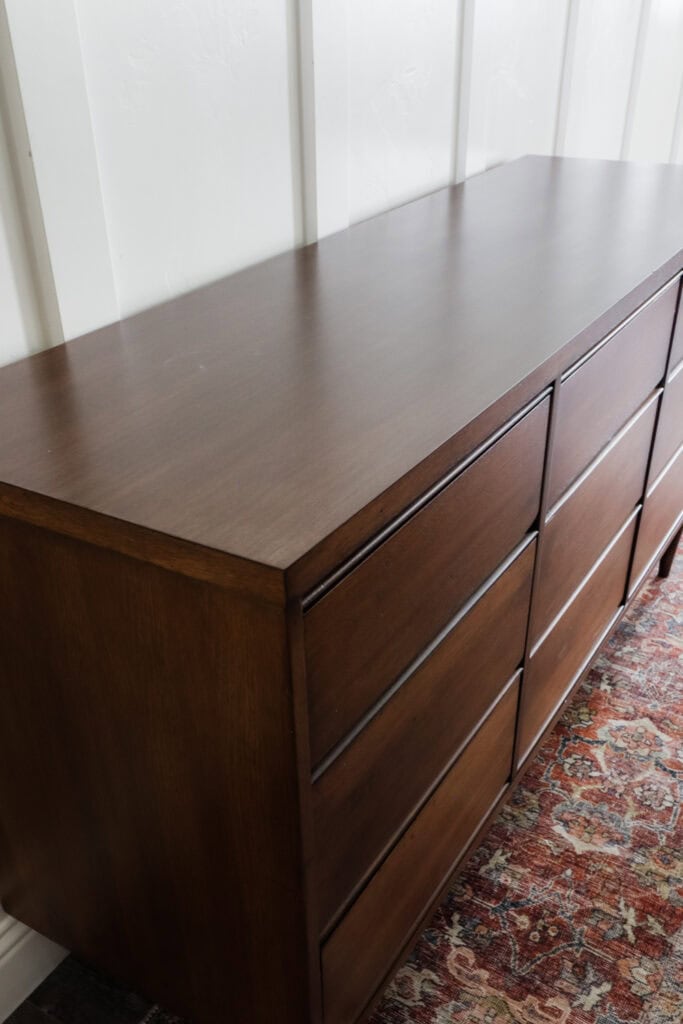 A wooden stained dresser with nine drawers
