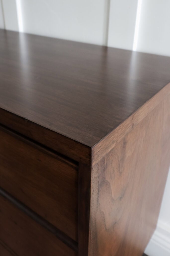 Close up of the top corner of a dark wooden dresser