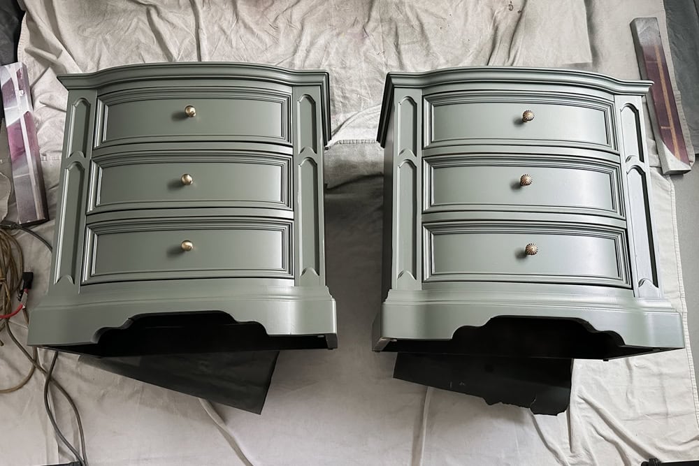 Two green nightstands with different knobs