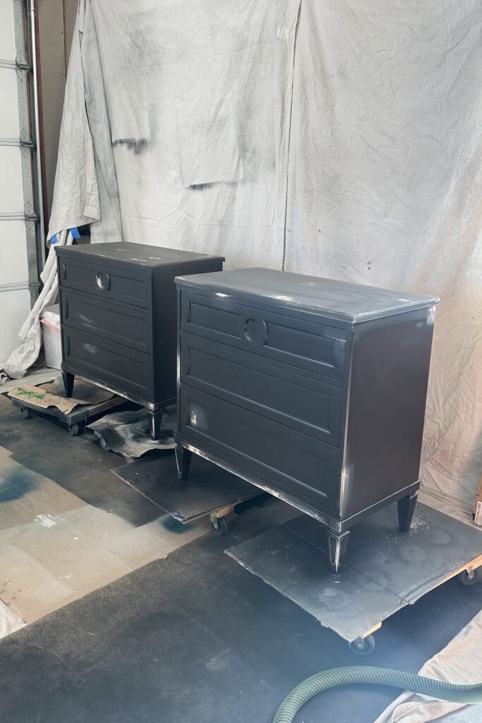Two black nightstands in garage with wood filler applied in different spots