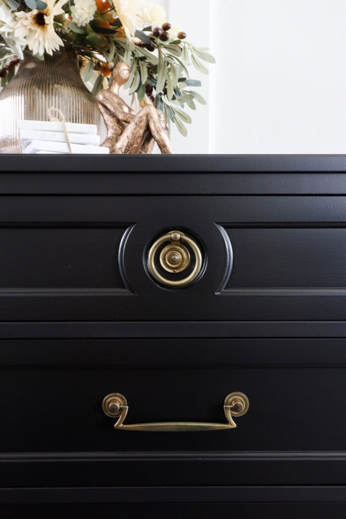 Black furniture with brass hardware and decor on top