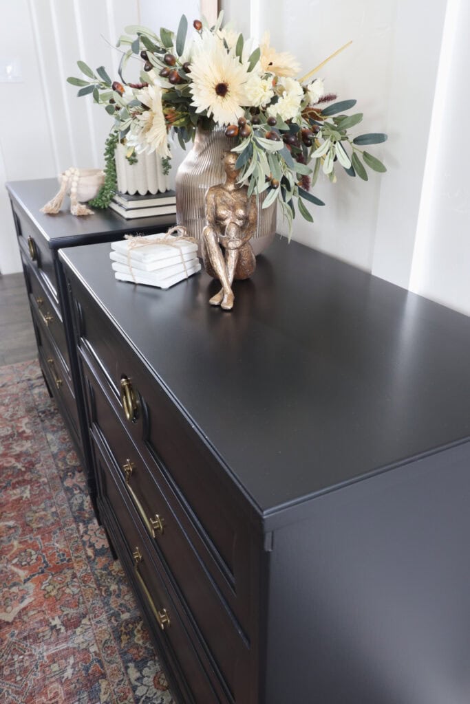 Top view of black nightstands with gold handles and decor on top