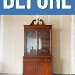 A wooden china cabinet with glass doors stands against a plain garage wall under a BEFORE sign.